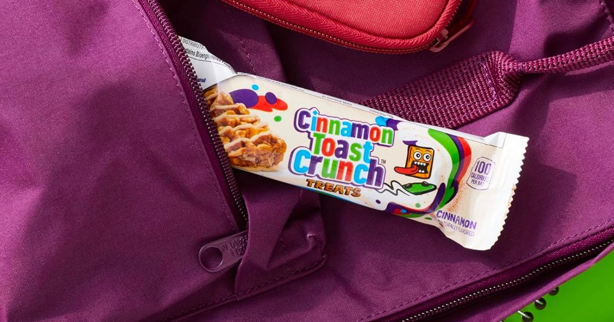a cinnamon toast crunch cereal bar partially in the front pocket of a purple backpack