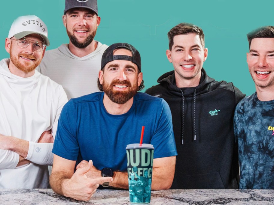 5 men sitting behind desk with dude perfect smoothie sitting on it. 