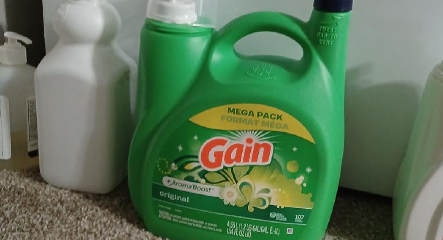 gain laundry detergent on the floor with other items around it