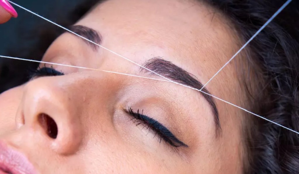 woman getting eyebrows threaded