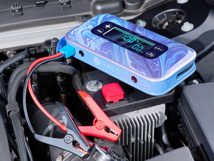 halo bolt jump starter kit on top of a car battery