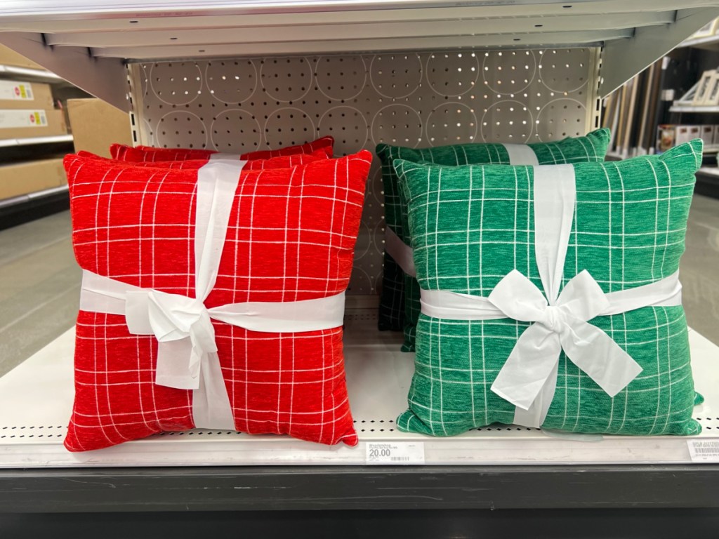 hand holding Wondershop Red or green Plaid Christmas Square Throw Pillows 2 Pack