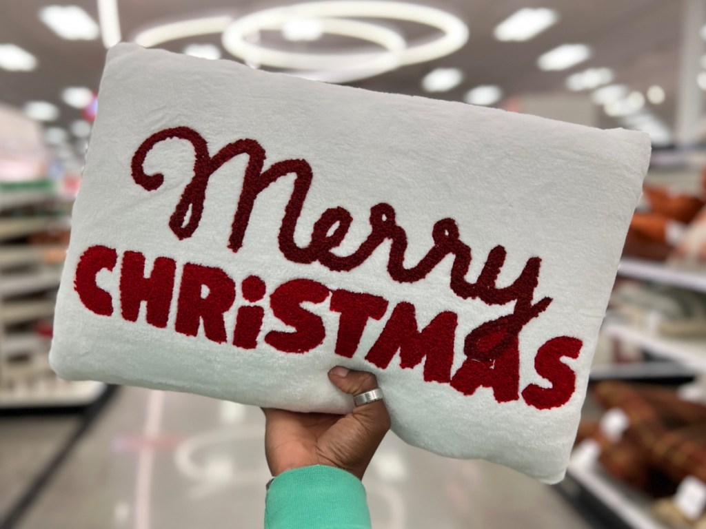 hand holding Wondershop'Merry Christmas Embroidered' Plush Lumbar Christmas Throw Pillow