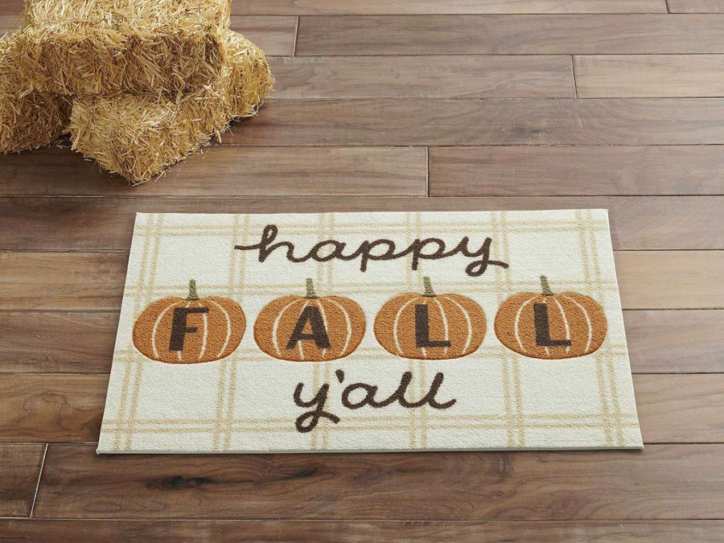 happy fall y'all rug on the floor next to hay