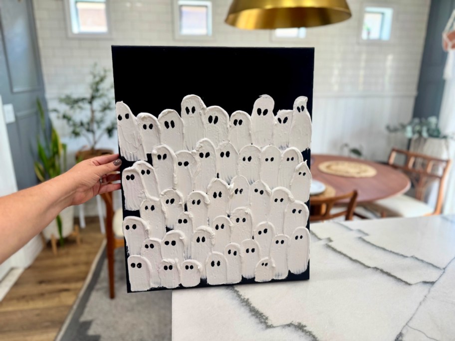 holding up a plastic ghost canvas after drying 
