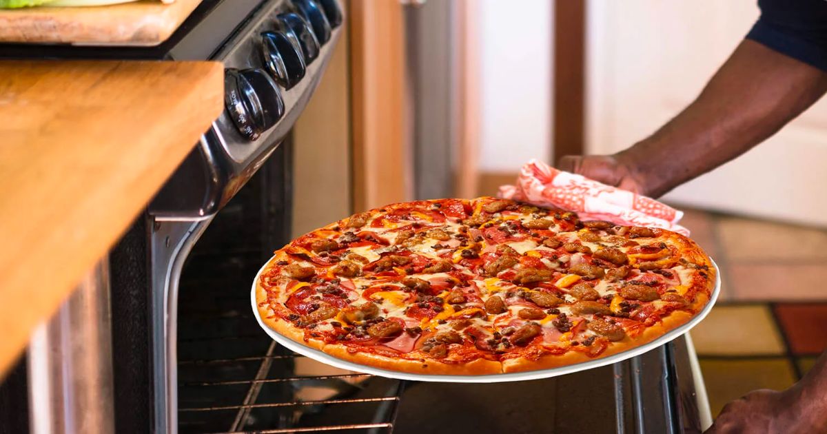man putting a papa murphy's meat pizza in a home oven
