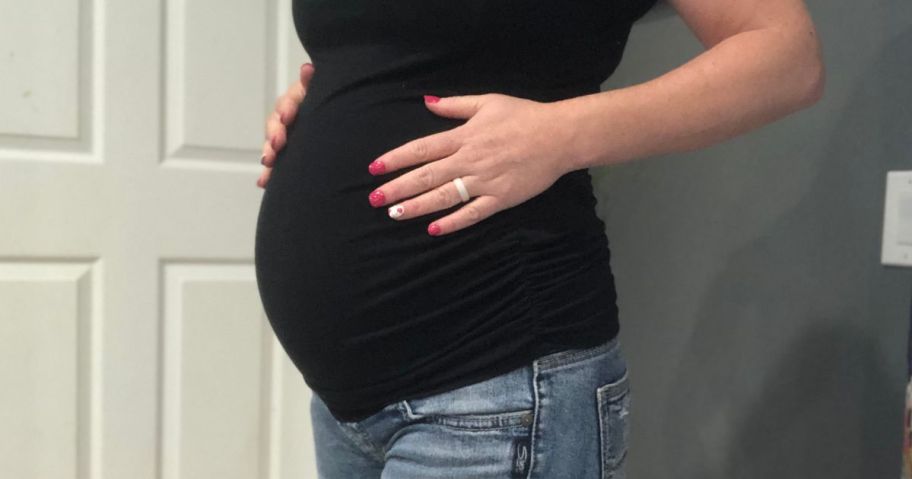 woman wearing walmart maternity top and holding belly