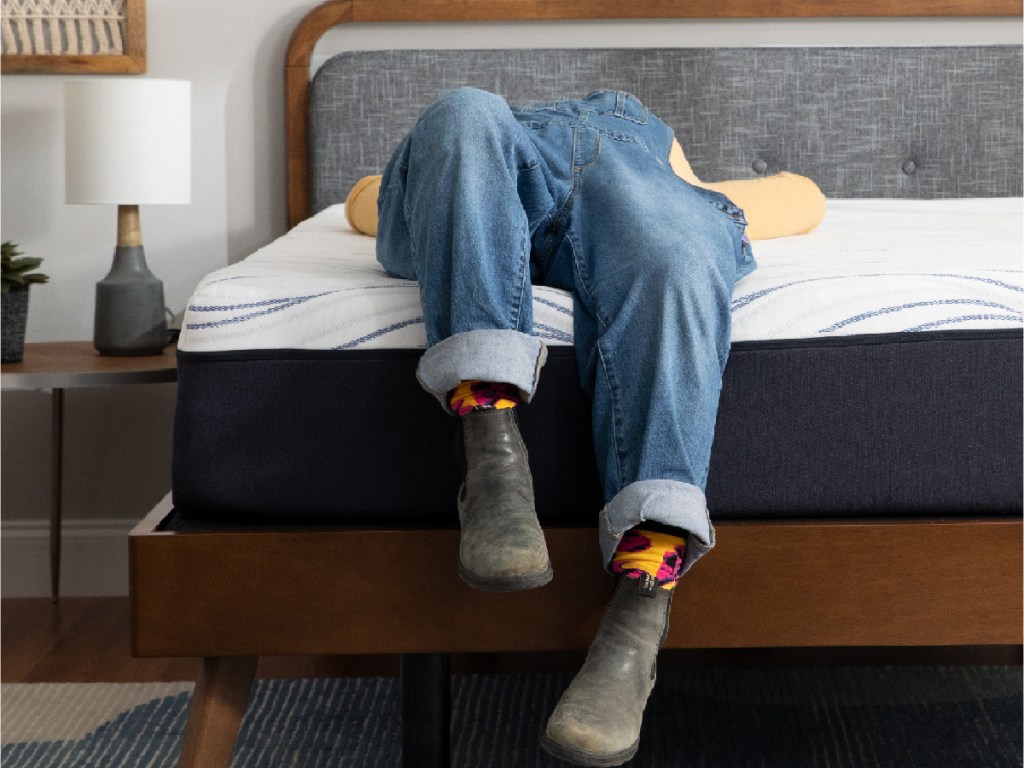 person in jeans relaxing on a mattress
