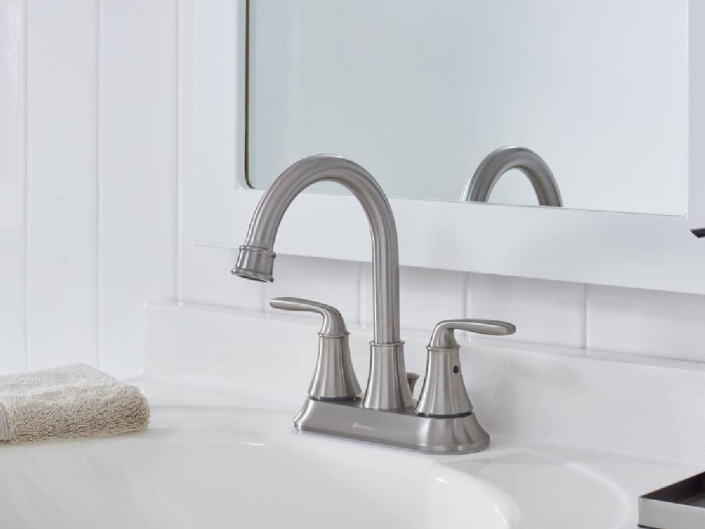 nickel brushed bathroom faucet displayed with mirror in the background and tool
