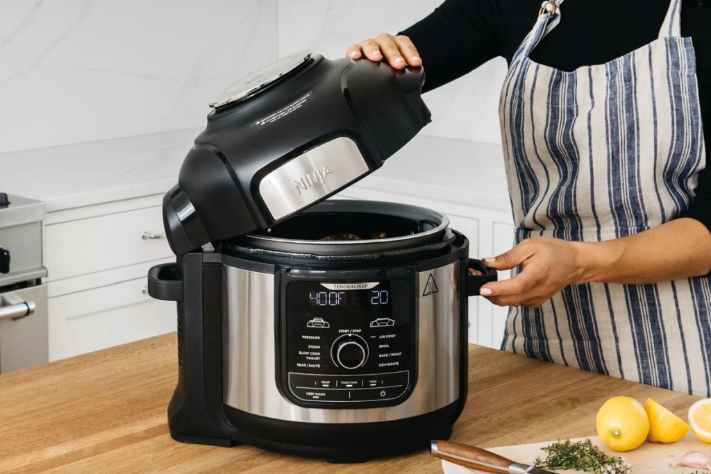 woman lifting lid of pressure cooker