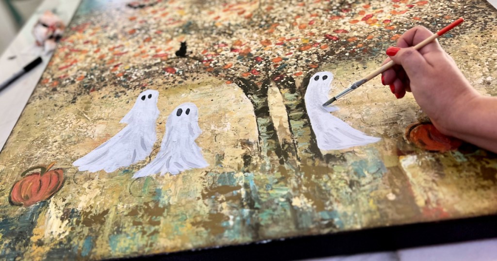 painting ghosts on a thrift store painting for halloween