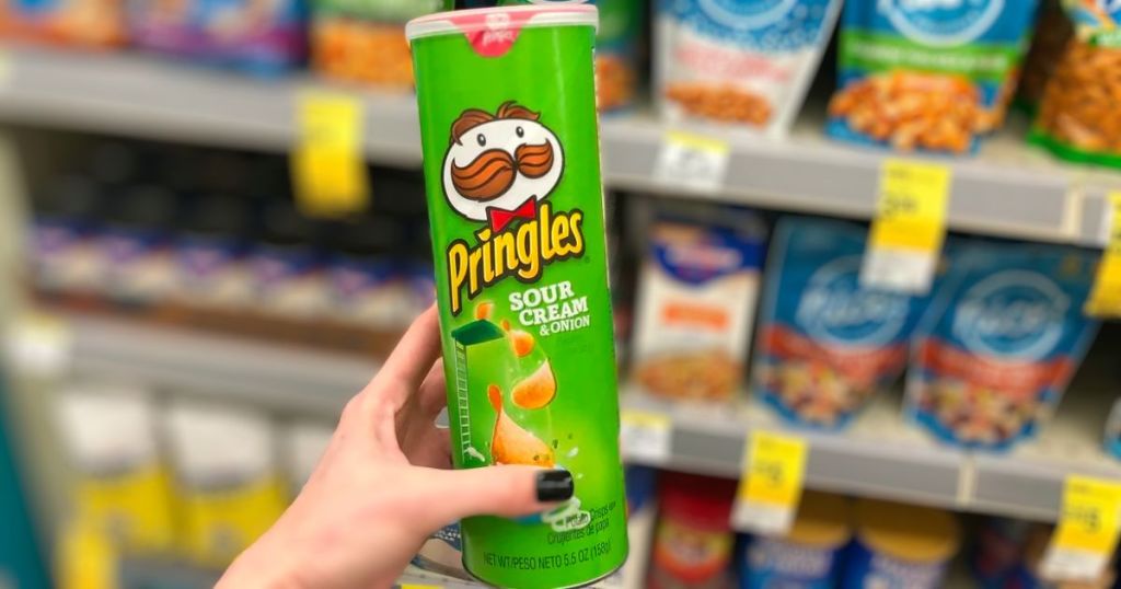 a womans hand holding a can of pringles sour cream potato crisps