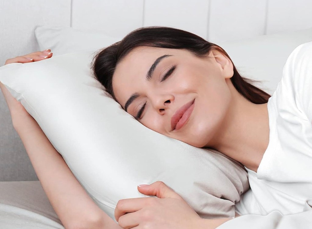 woman laying on white silk pillowcase