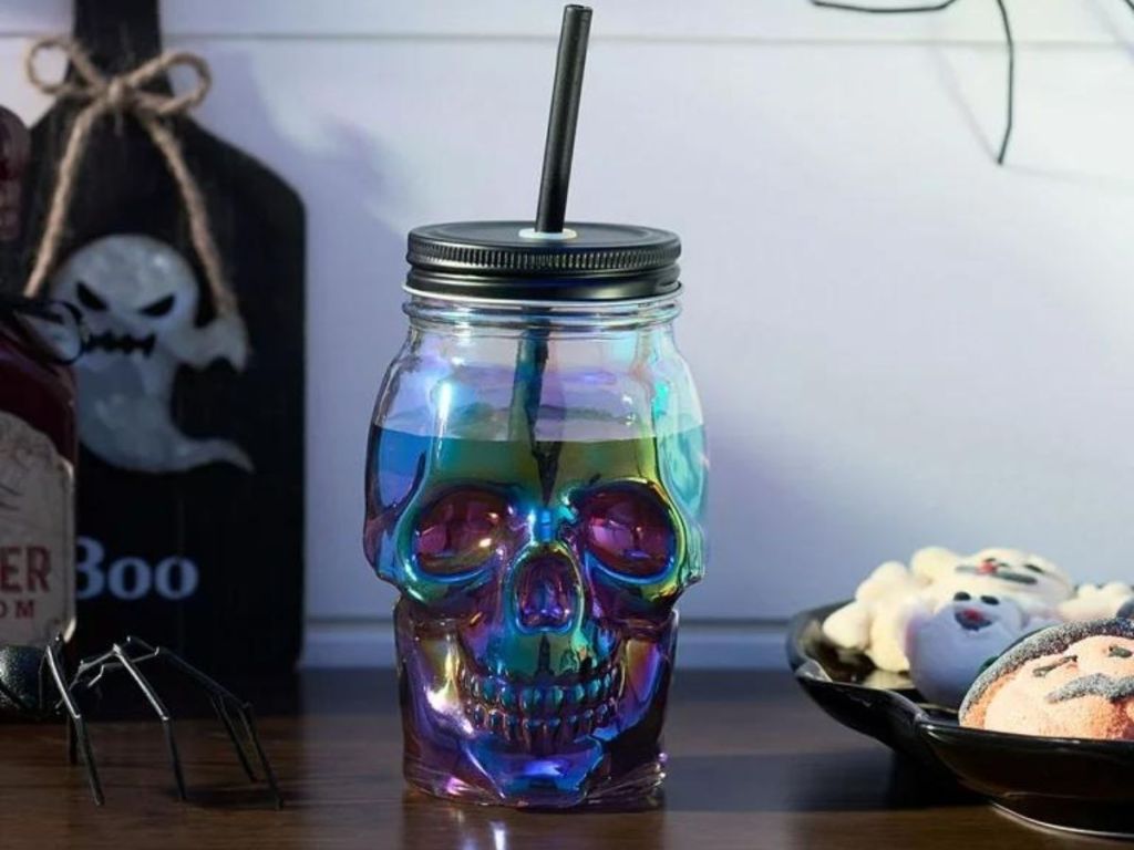 skeleton head glass sipper on table next to halloween cookies
