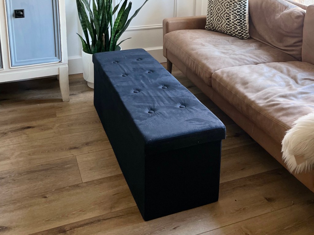 black storage ottoman next to couch