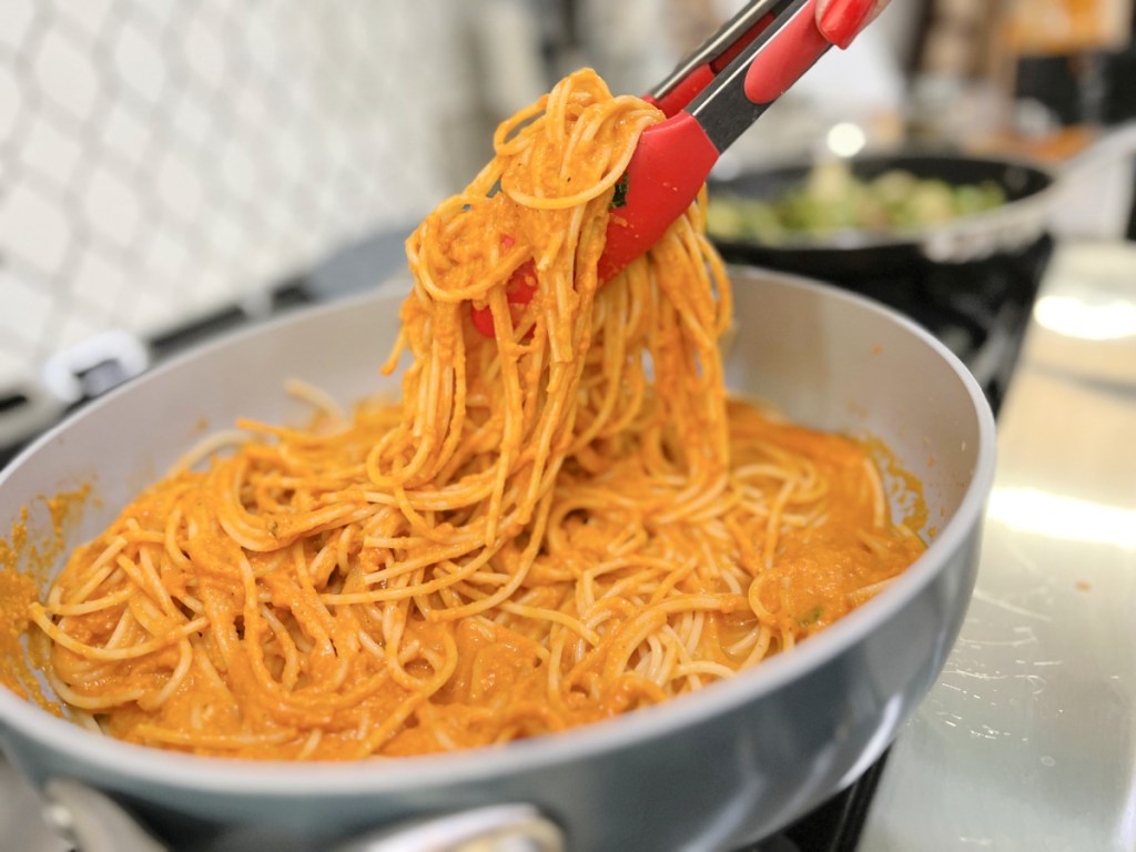 tossing butternut squash sauce with cooked spaghetti