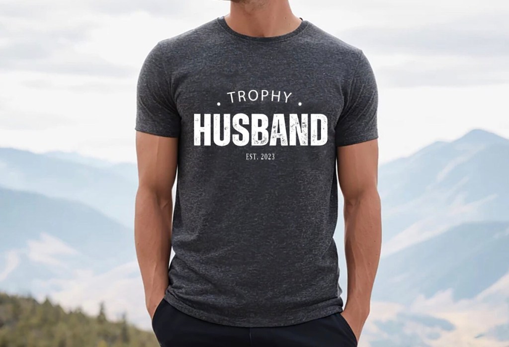man standing outside with dark gray trophy husband tshirt