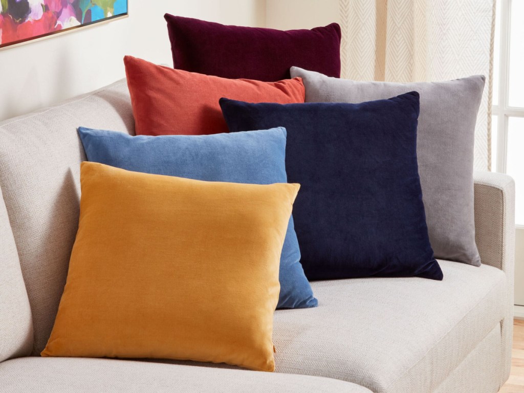 velvet throw pillows in multiple colors displayed on the couch