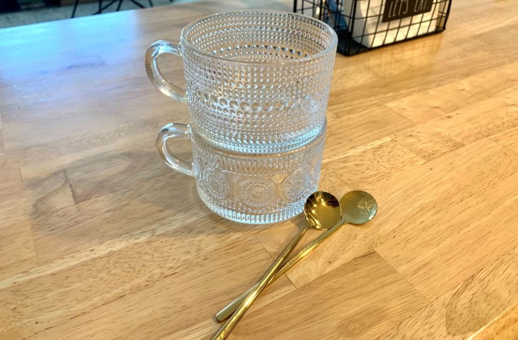 To clear Tej coffee mug stacked on top of each other with gold spoons