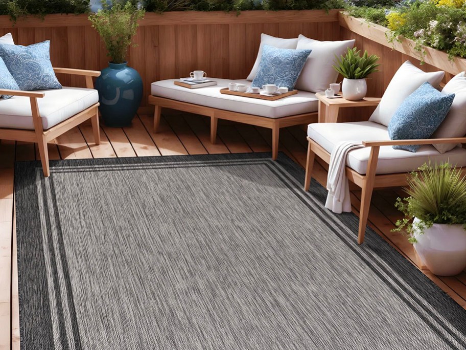 gray area rug outdoors next to patio furniture
