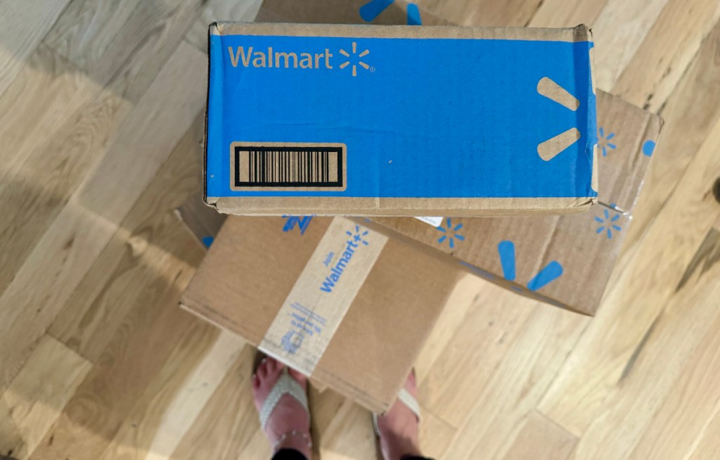 walmart boxes sitting on wood floor with persons feet