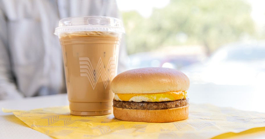 whataburger iced coffee next to a breakfast sandwich sitting on the table