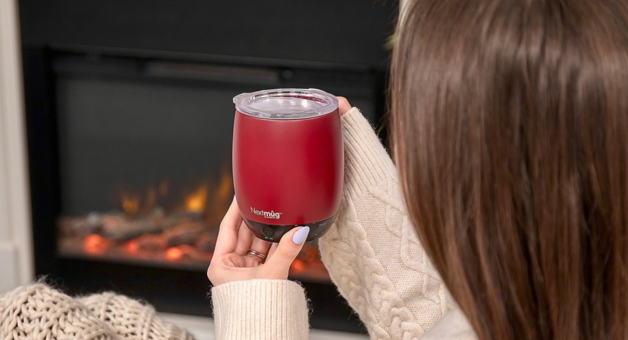 woman holding Nextmug in front of the fireplace