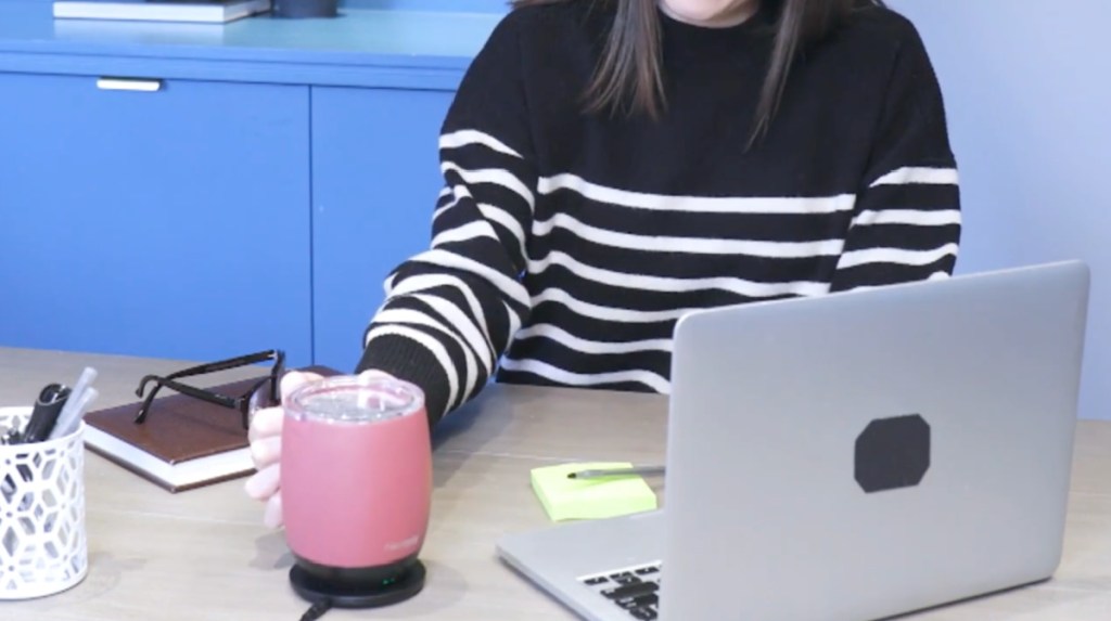 woman using next mug next to her laptop with coffee