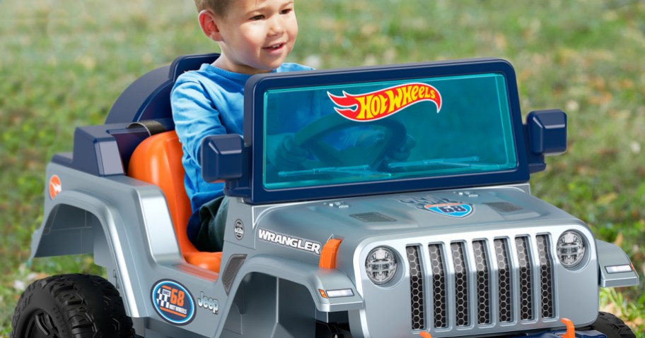 boy riding in a grey, blue, and orange power wheels hot wheels ride-on