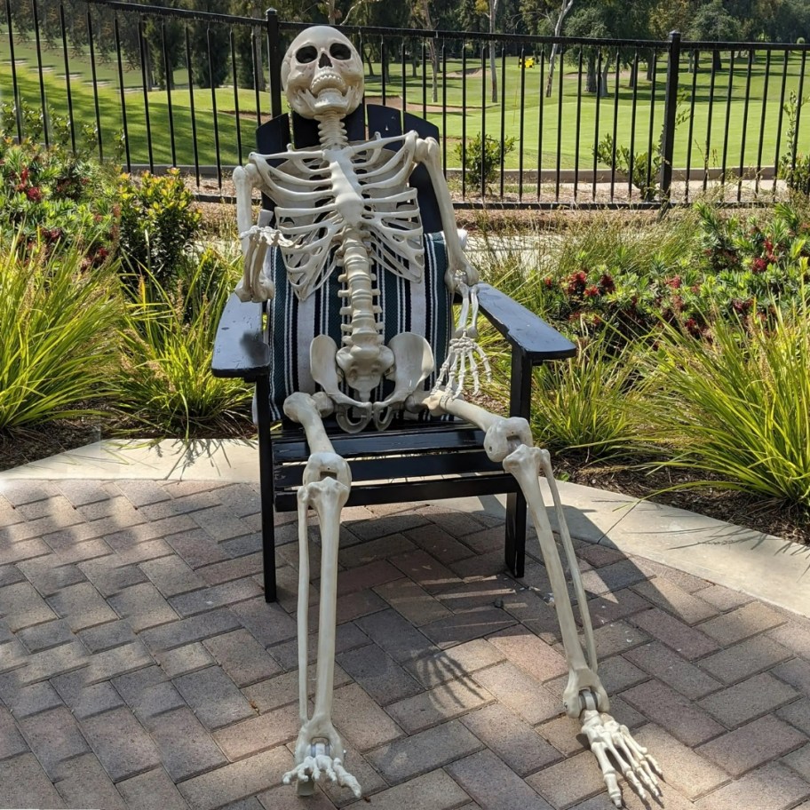 large posable skeleton in a rocking chair outdoors