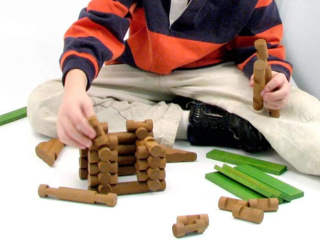 boy playing with the 97-piece Lincoln Log Set