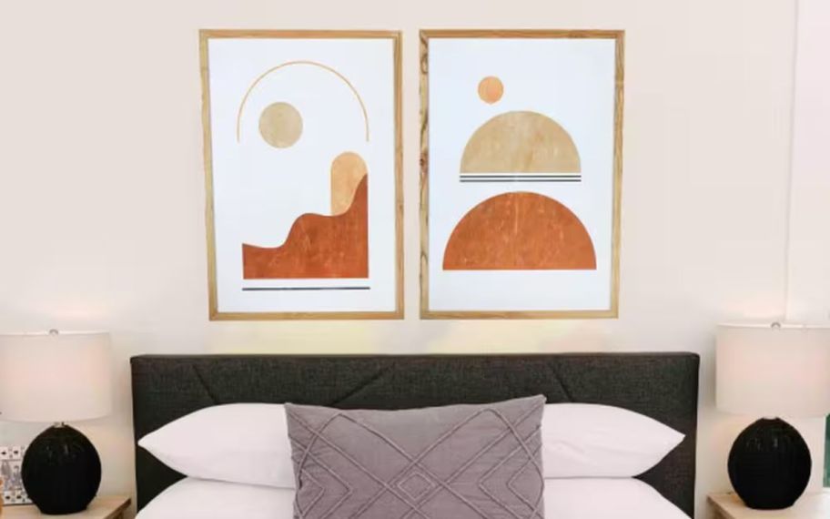 2 abstract framed art prints hanging above a bed