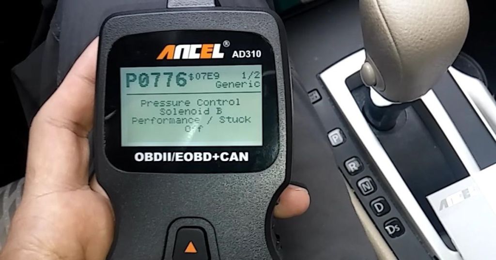 ANCEL AD310 Classic Enhanced Universal OBD II Scanner Car Engine Fault Code Reader in person's hand sitting in a car showing the menu