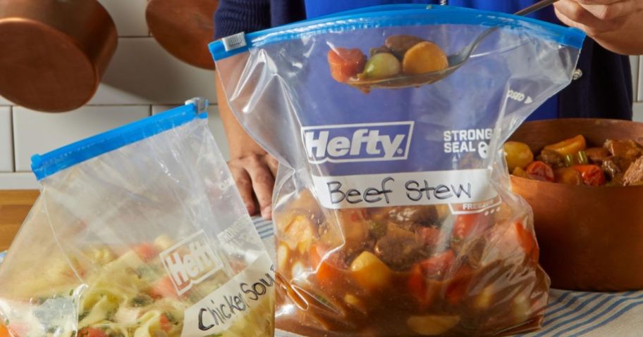 person putting food into hefty gallon size freezer slider bags