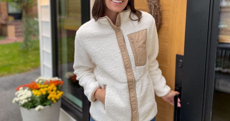 woman in cream sherpa snap jacket near front door