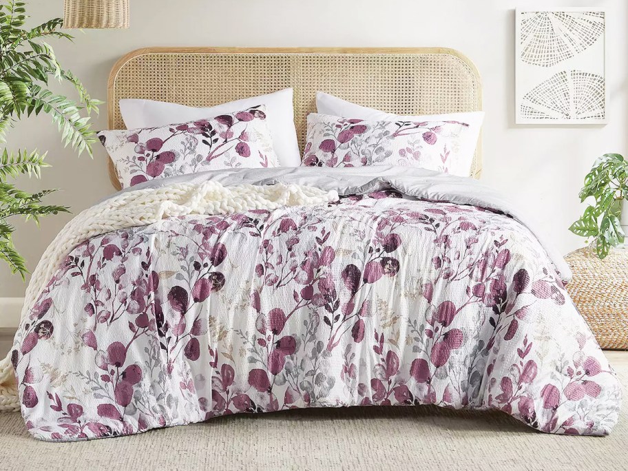 purple and white floral print comforter set on bed