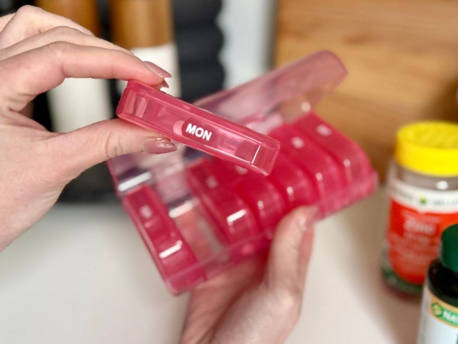 hand holding a box from AUVON Pill Organizer