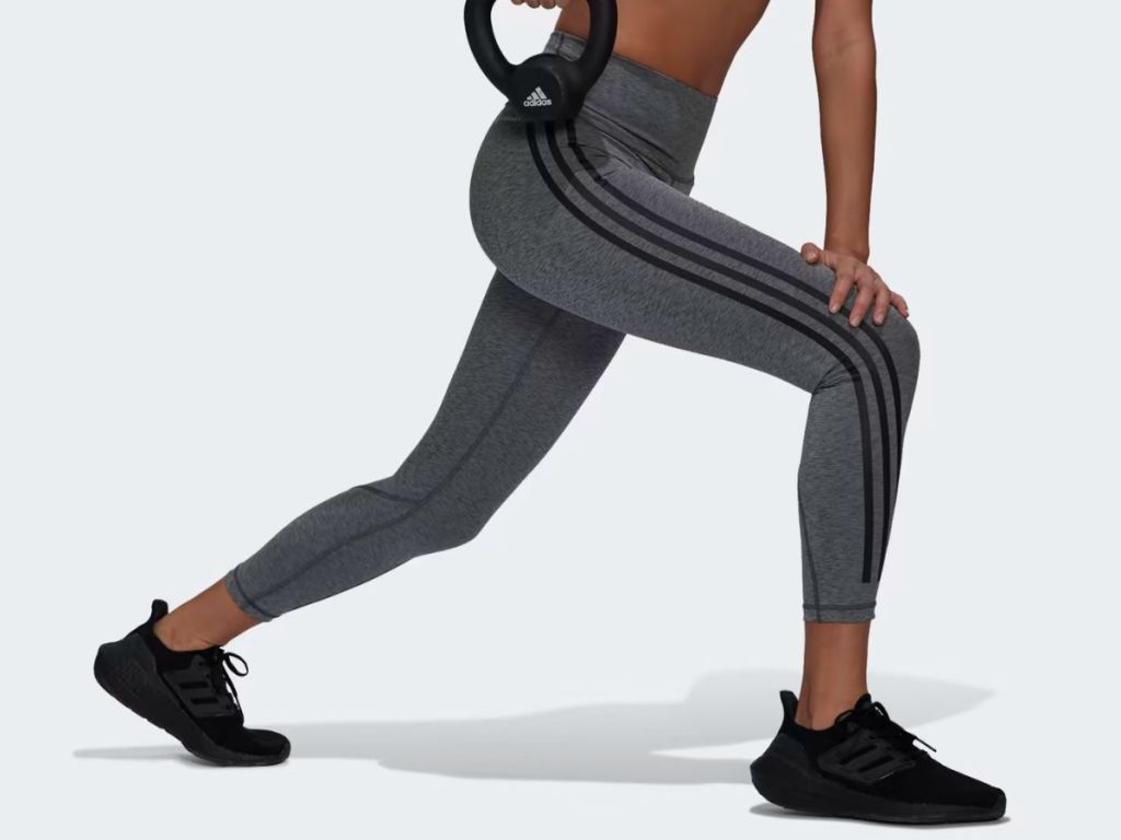 A woman exercising with Adidas Optime Trainicons Leggings 78
