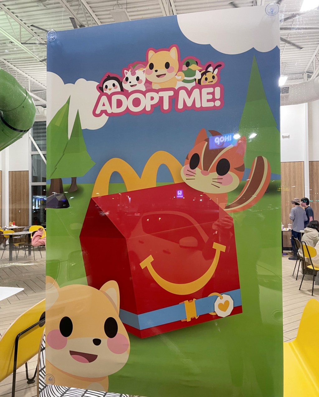 A sign in the McDonald's promotiing Adopt Me! Happy Meal Toys from the Roblox Game Adopt Me!