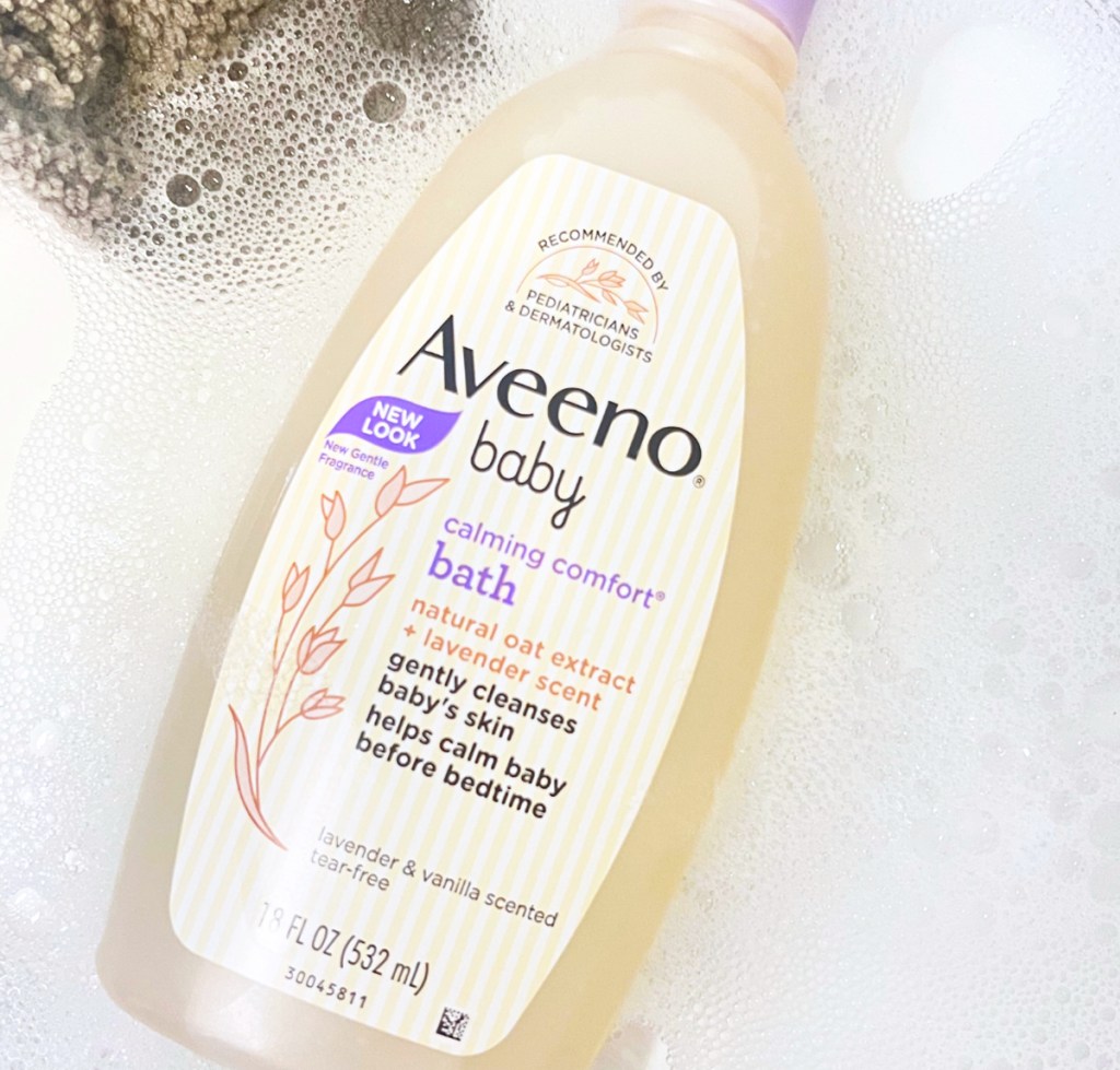 bottle of Aveeno Baby Calming Comfort Bath & Wash 18oz in soapy water