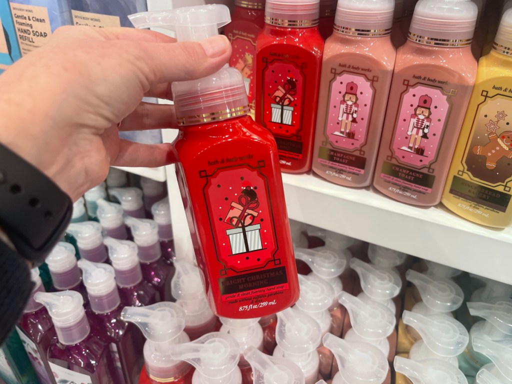 Person holding red colored bottle of Bath and body Works holiday hand soap