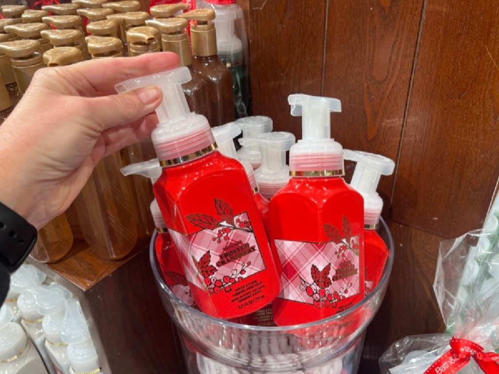 Woman taking about Bath and body Works, frosted cranberry soap out of basket in store