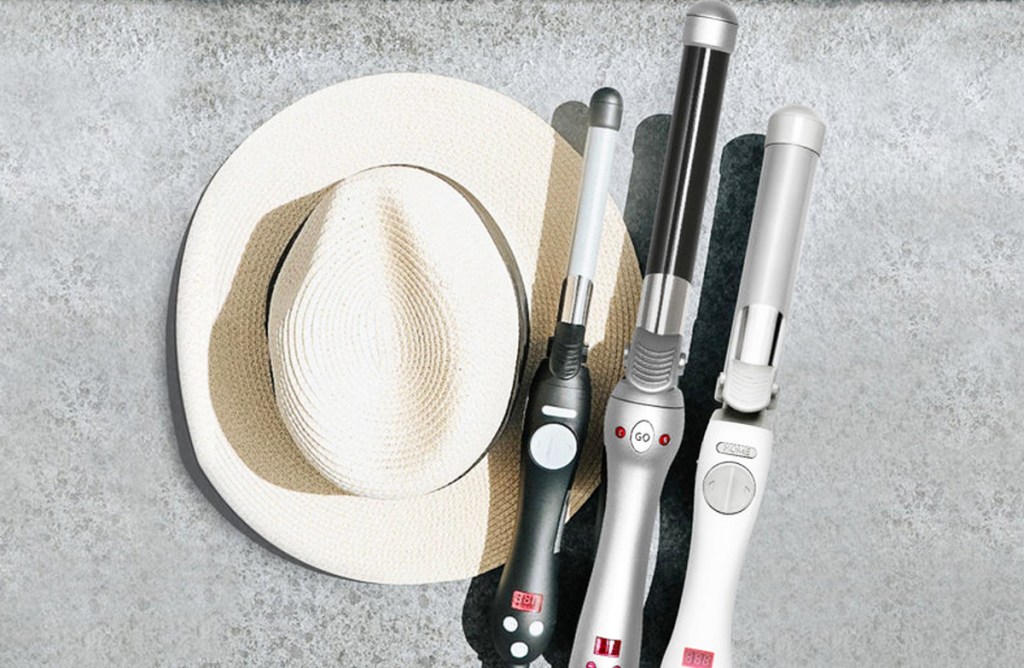 three curling iron next to a hat