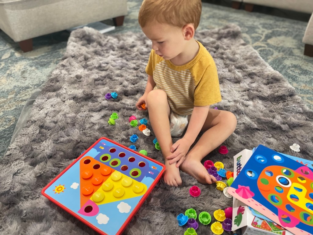 toddler playing with button art activity set