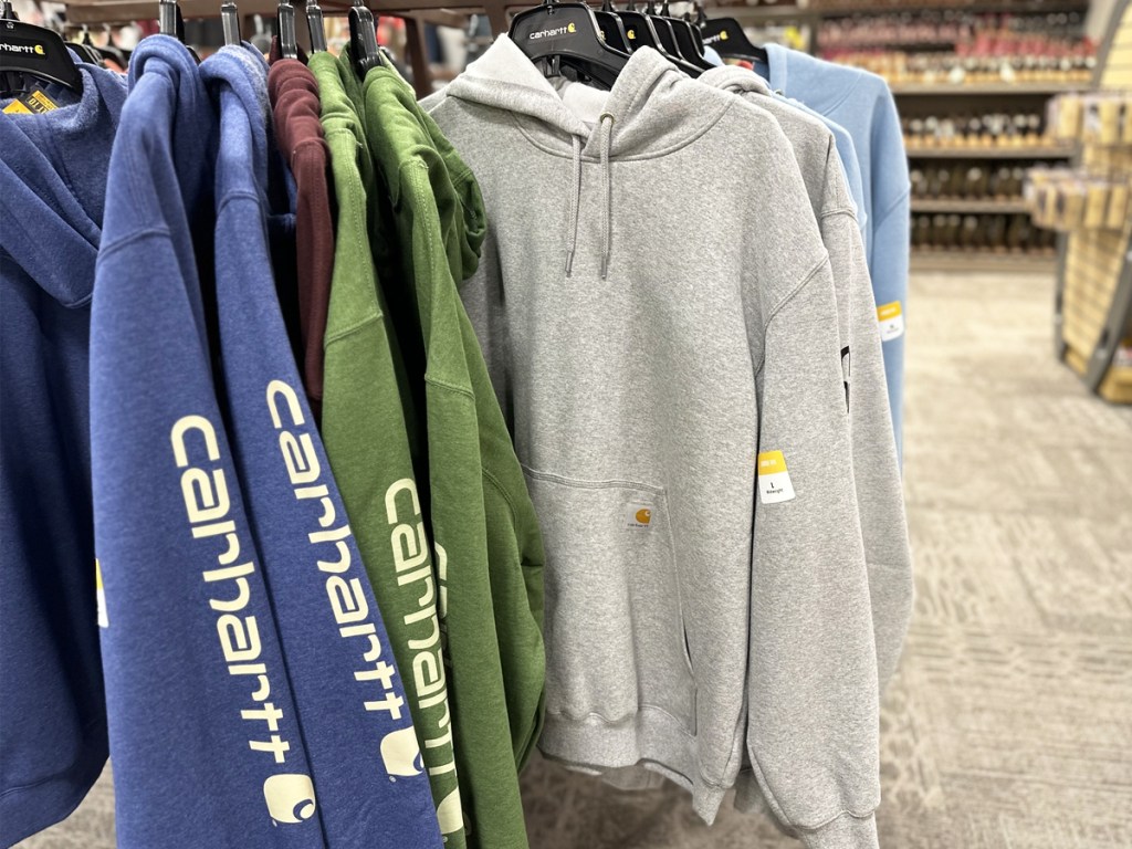 blue, green, and light grey carhartt hoodies on store display rack