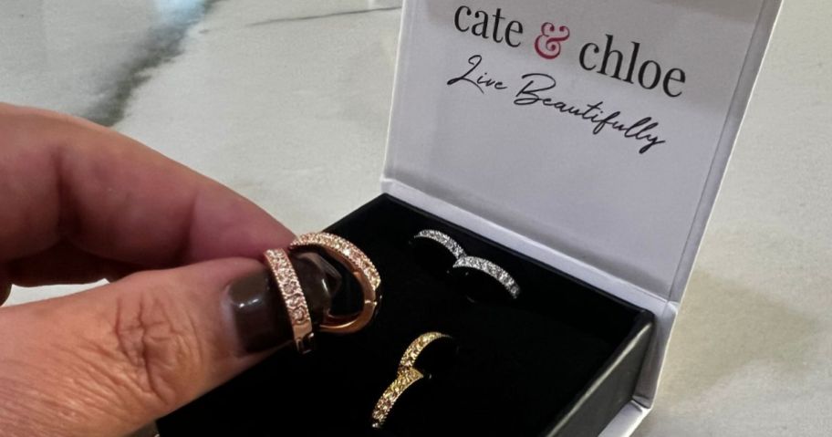 Cate & Chloe Lydia hoop earrings with a hand holding one rose gold pair and a yellow gold and white gold pair nearby in the box