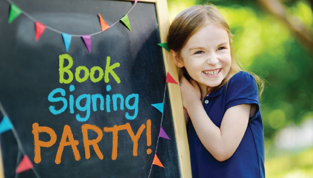 A student author next to a book signing sign