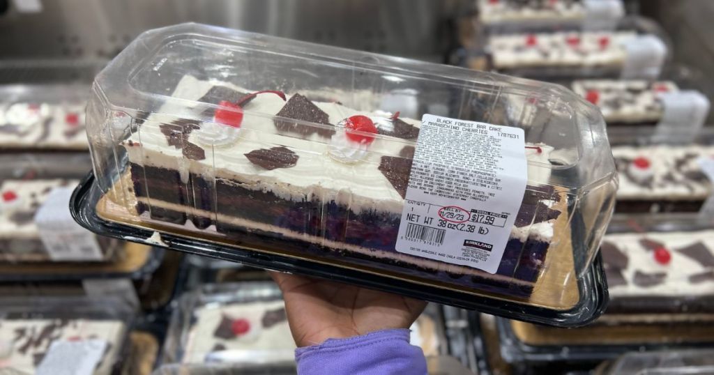 A hand holding a Costco Black Forest Cake and Cherries