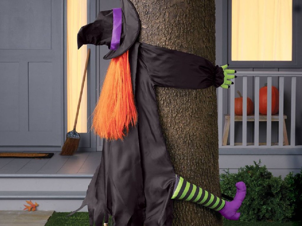 Crashing Witch Halloween Decorative Prop displayed on a tree outside of a house