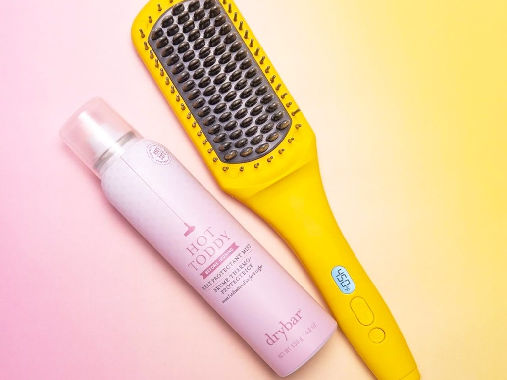 bottle of heat protectant next to heated straightening brush